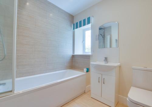 ein weißes Badezimmer mit einer Badewanne und einem Waschbecken in der Unterkunft Three Halfway Houses in Hawes