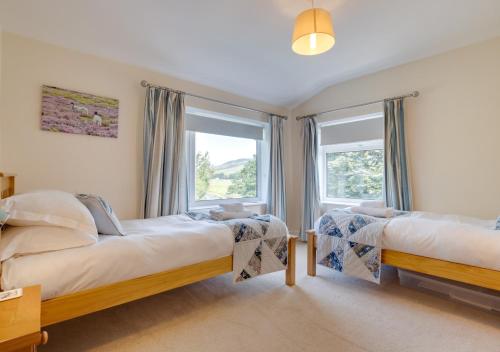 a bedroom with two beds and a window at Three Halfway Houses in Hawes