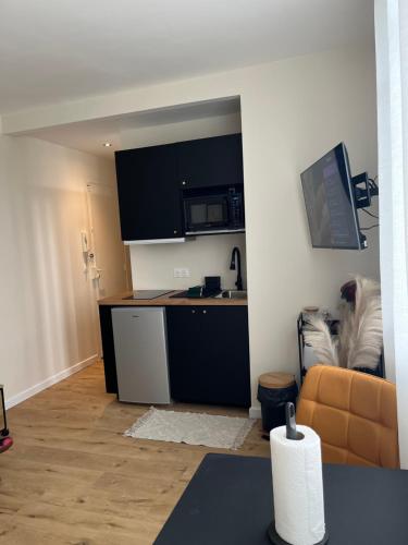 ein Wohnzimmer mit einer Küche und einem Sofa in der Unterkunft Appartement plein centre ville d’Alfortville in Alfortville