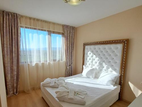 a bedroom with a white bed with a large window at Hotel Seasons 3 in Sunny Beach