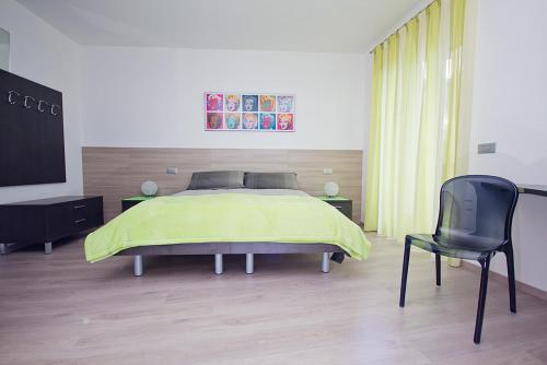 a bedroom with a bed and a black chair at Il Sogno in Avio