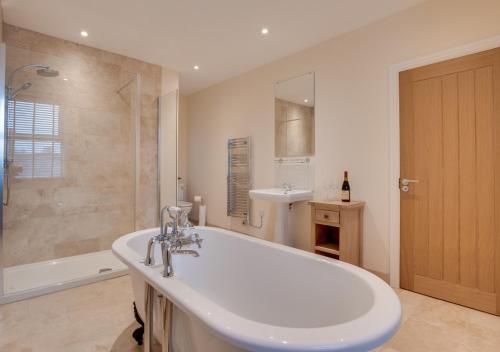 ein Bad mit einer Badewanne, einem Waschbecken und einer Dusche in der Unterkunft Wilmer House in Hawes