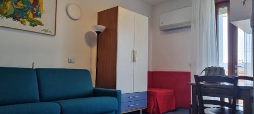 a living room with a blue couch and a table at Appartamenti Katja in Bibione