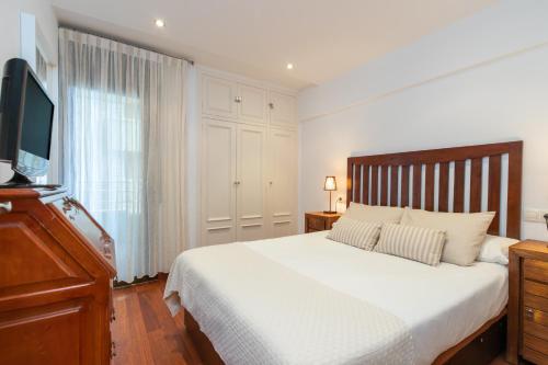 a bedroom with a bed and a flat screen tv at Maria Beach in Platja  d'Aro
