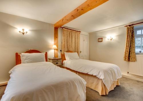1 dormitorio con 2 camas y ventana en Barn Owl Cottage, en Masham