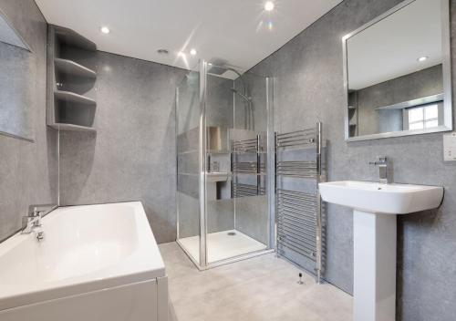 a bathroom with a shower and a sink and a tub at Lower Gill Farmhouse in Tosside