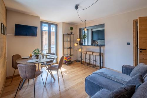 un salon avec un canapé bleu et une table dans l'établissement Newly renovated apartment with Mont Blanc view, à Chamonix-Mont-Blanc