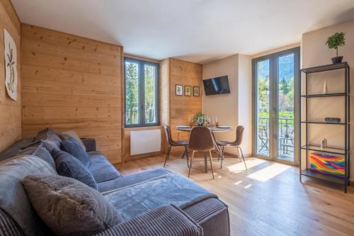 een woonkamer met een blauwe bank en een tafel bij Newly renovated apartment with Mont Blanc view in Chamonix-Mont-Blanc