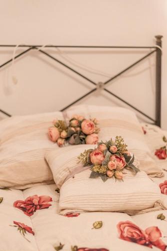 a bed with two pillows with flowers on it at Il Nido del Vicolo delle scuole Pie in Città della Pieve