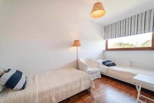 1 dormitorio con cama, sofá y ventana en Nowoczesny Apartament w Helskiej Villi w Helu en Hel