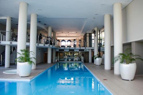 a large pool in a building with columns at Knightsbridge Superior Apartments in Cape Town