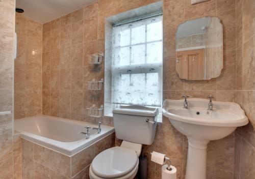 a bathroom with a toilet and a sink and a tub at Church View - Askrigg in Askrigg