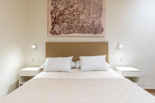 a bedroom with a large bed with two white pillows at Apartamentos Cervantes 17 in Seville