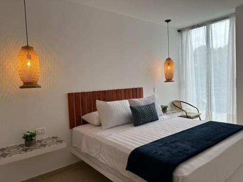 1 dormitorio con 1 cama grande y 2 luces colgantes en Aloja-T Hispania, Ant, en Hispania
