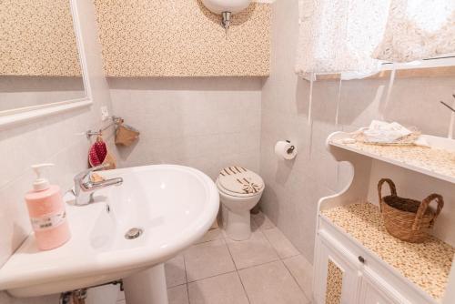 a white bathroom with a sink and a toilet at Il Nido del Vicolo delle scuole Pie in Città della Pieve