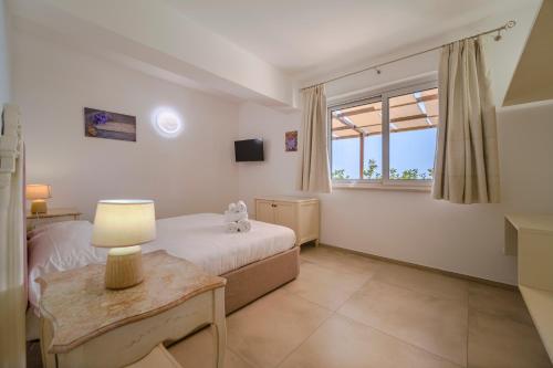 a bedroom with a bed and a table and a window at Don Vittorio Country Village in Taormina
