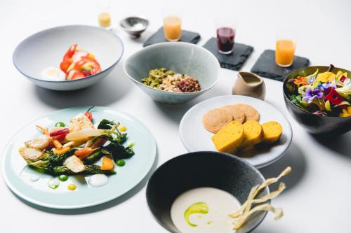a table with plates of food and bowls of food at Garrya Nijo Castle Kyoto in Kyoto