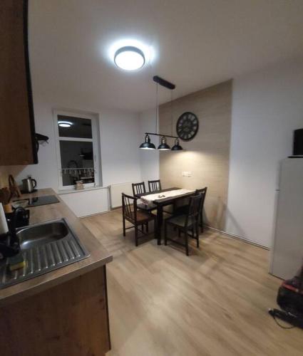 a kitchen and dining room with a table and chairs at Apartament Blisko Granicy in Kunowice