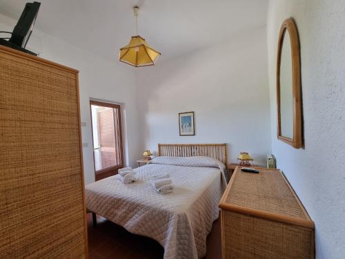 a bedroom with a bed with a table and a mirror at Hotel Portofina in Santa Marinella