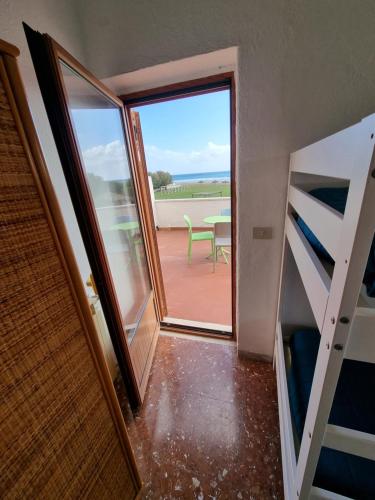 a room with a balcony with a view of a table at Hotel Portofina in Santa Marinella