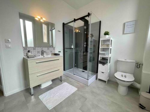 a bathroom with a glass shower and a toilet at L’Accostage in Dieppe