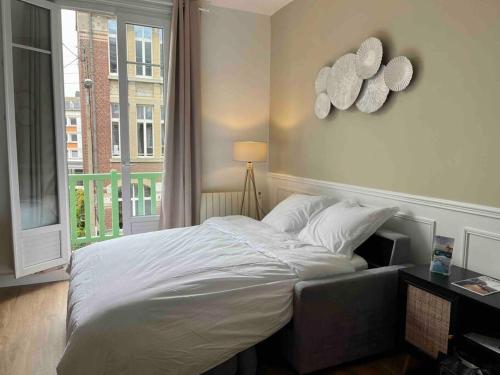 1 dormitorio con 1 cama grande y ventana en L’Accostage en Dieppe