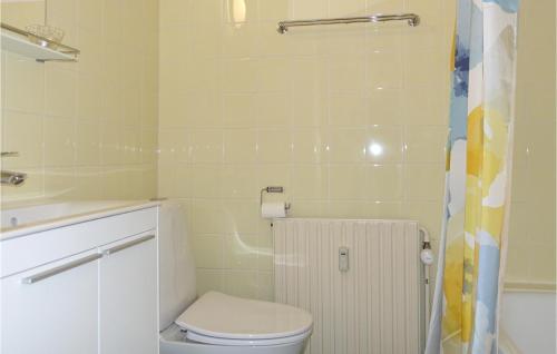 a small bathroom with a toilet and a shower at Cozy Apartment In Aakirkeby in Åkirkeby