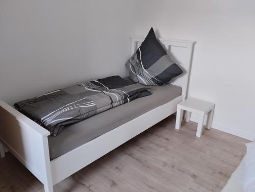 a white bed with black pillows and a table at Schöne Ferienwohnung Nähe Biggesee 