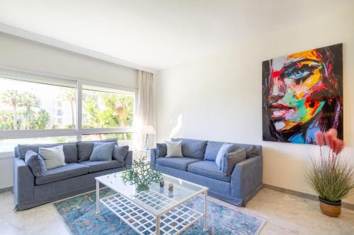 un soggiorno con 2 divani e un dipinto sul muro di MARBELLA BANUS SUITES - Banus Playa Rocio Beachfront Complex a Marbella