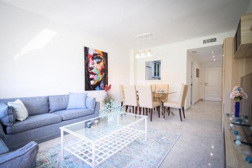 ein Wohnzimmer mit einem Sofa und einem Tisch in der Unterkunft MARBELLA BANUS SUITES - Banus Playa Rocio Beachfront Complex in Marbella