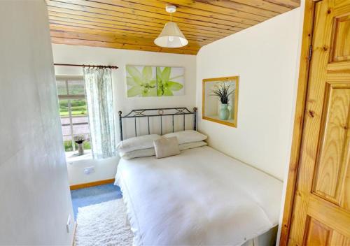 une chambre avec un grand lit avec un plafond en bois dans l'établissement 2 Bransdale Cottage, à Glaisdale