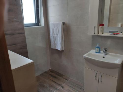 a white bathroom with a sink and a mirror at Mali Raj in Soko Banja