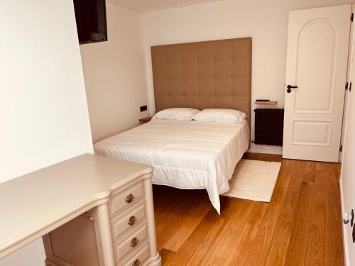 1 dormitorio con cama blanca y suelo de madera en Villa Clásica en Santiago en Santiago de Compostela