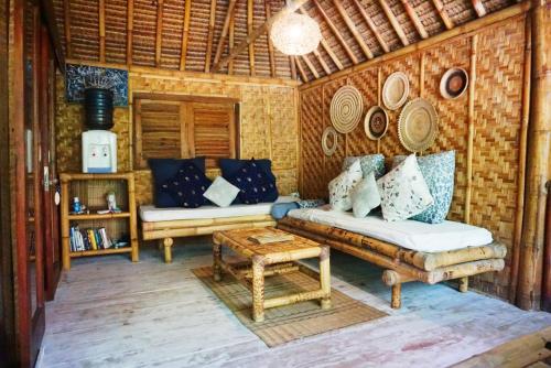 un soggiorno con un divano e un tavolo di Meno Island Villas a Gili Meno