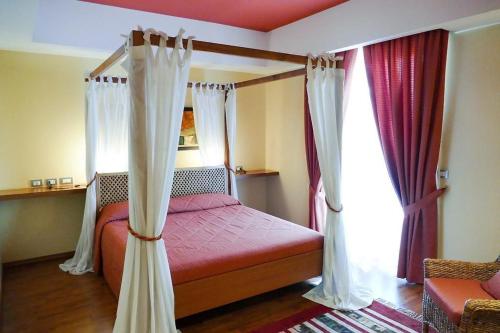 Un dormitorio con una cama con dosel y cortinas. en STELLA CHARMING & LUXURY ROOMS, en Conversano