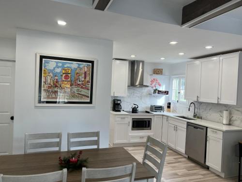 a kitchen with white cabinets and a table and chairs at 1st floor apt 3 bed/ 2 bath in downtown orlando in Orlando