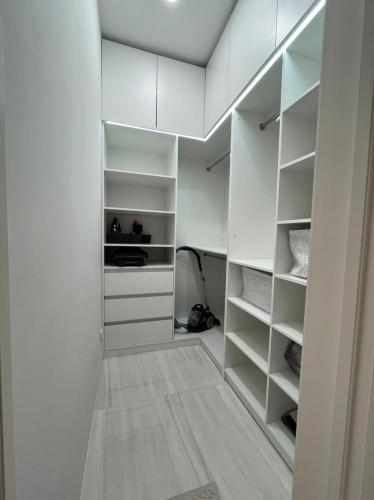 a white walk in closet with white shelves at Almira in Dushanbe