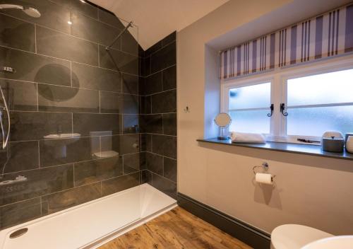 a bathroom with a bath tub and a window at 2 Railway Cottages in Selside