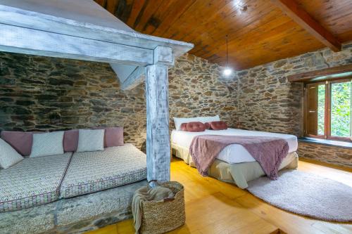 - une chambre avec deux lits et un canapé dans l'établissement Casas del Molino - Muiños do Mainzoso Turismo Rural, à Paderne
