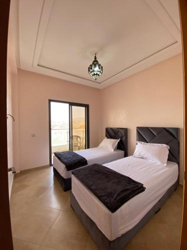 a bedroom with two beds and a chandelier at House of banana beach aourir in Aourir