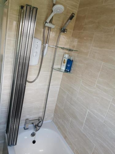 a bathroom with a shower with a sink and a shower head at Goldthorn Wolverhampton sleeps 5 long term comfortably and families in Wolverhampton