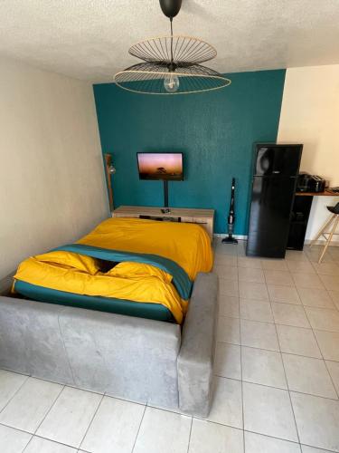 - une chambre avec un lit et une couverture jaune dans l'établissement Appartement en résidence-Avignon, à Avignon