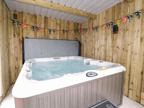 a jacuzzi tub in a wooden building with flags at Salem in Prestatyn