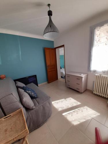 a living room with a couch and a window at Chambre indépendante in Avignon