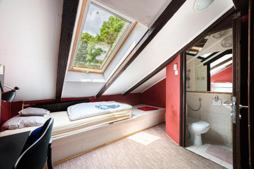 ブダペストにあるGul Baba Saray Apartmentsの小さな屋根裏のベッドルーム(ベッド1台、トイレ付)