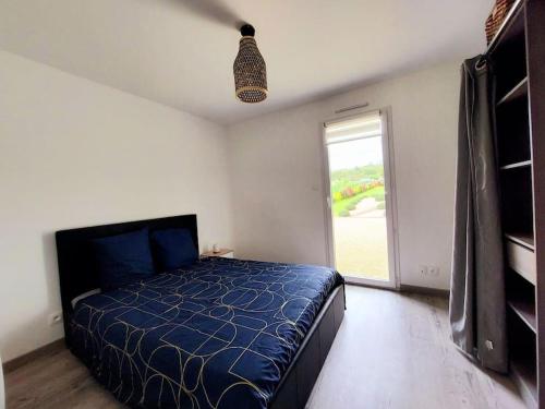 um quarto com uma cama azul e uma janela em La Maison de Kahyna classé 3 étoiles em Roiffé