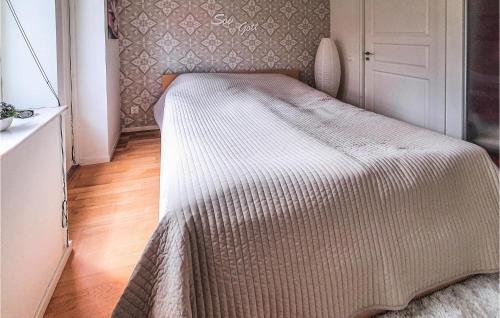 a small bedroom with a bed with a white blanket at Awesome Home In Hörby With Kitchen in Hörby