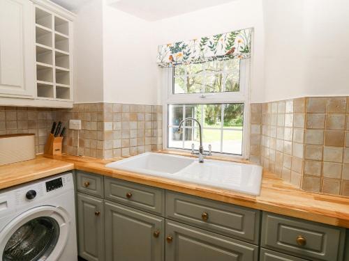 a kitchen with a sink and a window at Mill House Main House in Pwllheli