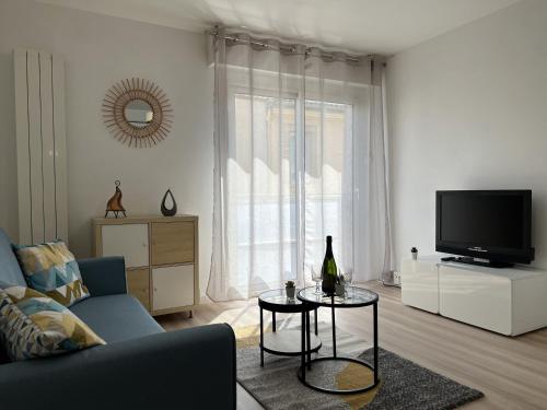 - un salon avec un canapé, une télévision et une table dans l'établissement T2 Centre ville avec parking gratuit, à Toulouse
