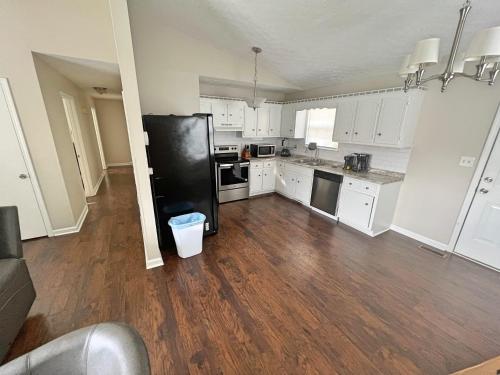 a kitchen with white cabinets and a black refrigerator at Beautiful home in a nice place in Clarksville